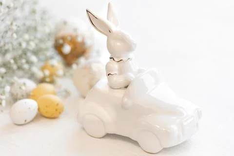 Easter background with a ceramic hare in the car and eggs on a white background, Stock Photos