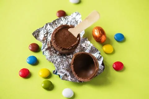 Easter background from chocolate Easter eggs and colorful candies on a green  Stock Photos