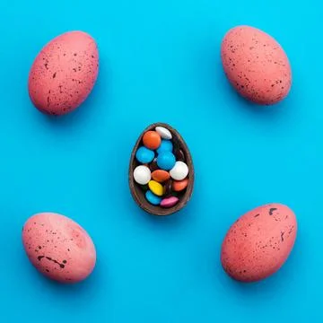 Easter background with chocolate eggs and multi-colored sweets, top view Stock Photos
