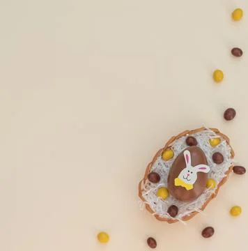 Easter background with colored brown and yellow choco Easter eggs in egg bask Stock Photos
