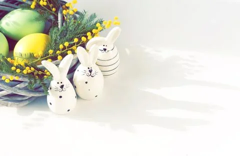 Easter background . Colored deco eggs ,flowers mimosa in a wicker basket and Eas Foto stock