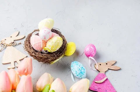 Easter background with colored Decorative eggs in the nest and tulips Stock-Fotos