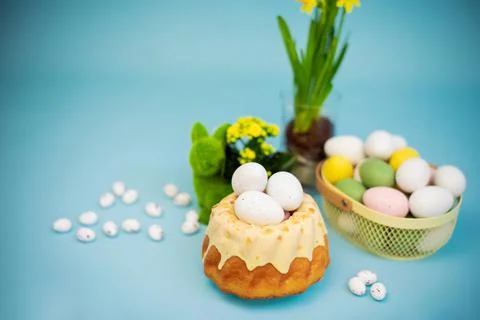Easter background with colored eggs, easter cake, spring flowers on a blue Stock Photos