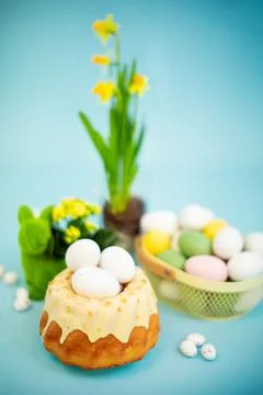 Easter background with colored eggs, easter cake, spring flowers on a blue Stock Photos