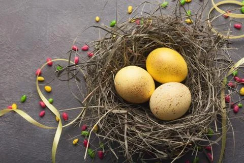 Easter background. Colored eggs in nest on gray stone surface Foto stock