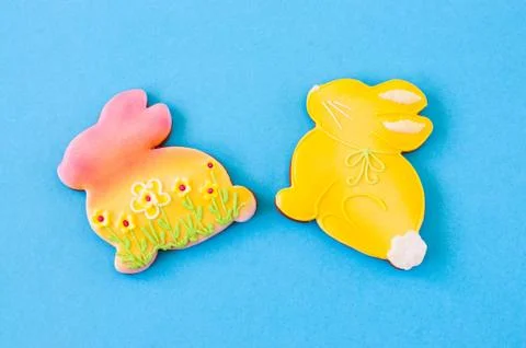 Easter background concept. Colored bunnies on blue background. Stock Photos
