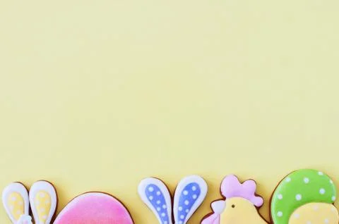 Easter background concept. Colored easter cookies on yellow background. Stock Photos