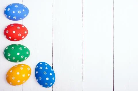 Easter background with copy space. Easter eggs on white wooden background. .. Stock Photos