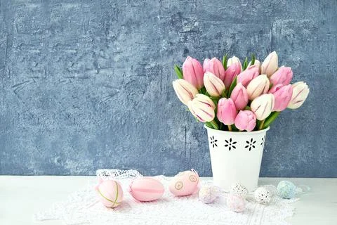 Easter background. Decorative Easter eggs and pink tulips in vase. Copy space Stock Photos
