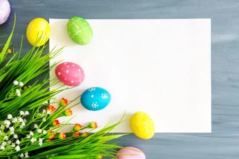 Easter background with Easter eggs and spring flowers. Top view with copy spa Stock Photos