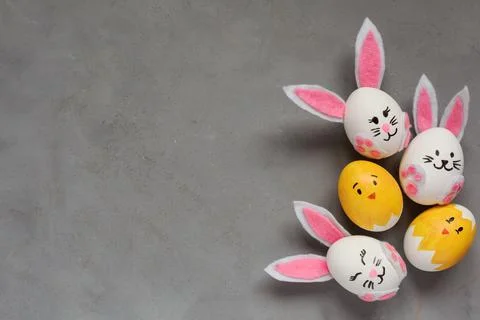 Easter background with Easter eggs decorated as rabbits and chicken on gray Stock Photos