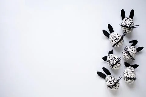 Easter background with Easter eggs, decorated as funny black and white bunnies Stock Photos