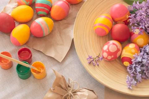 Easter background with Easter multi-colored eggs, paints and spring flowers. Stock Photos