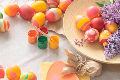Easter background with Easter multi-colored eggs, paints and spring flowers on Stock Photos