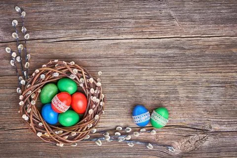 Easter background. Easter willow wreath and colorful Easter eggs on old wooden Stock Photos