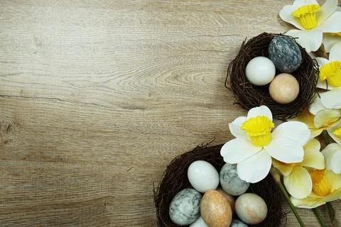 Easter background with eggs and flowers bouquet top view on wooden background Stock Photos