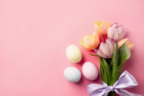 Easter background with eggs and tulips on pink backdrop, top view flat lay Stock Photos