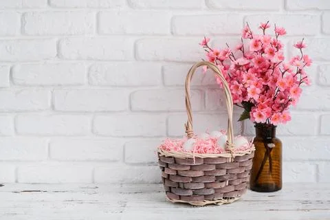 Easter background with eggs in basket and spring flowers in vase Stockfoto's