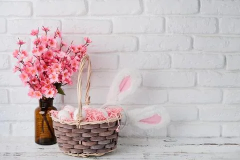 Easter background with eggs in basket and spring flowers in vase Stockfoto's