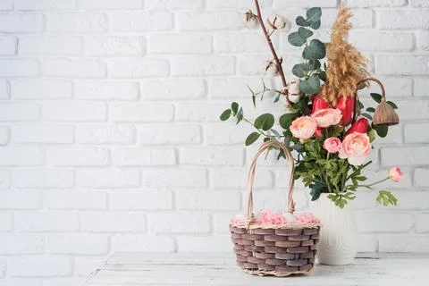 Easter background with eggs in basket and spring flowers in vase 库存照片
