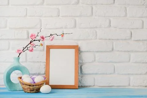 Easter background with eggs in basket, spring flower and white frame for mock 스톡 사진