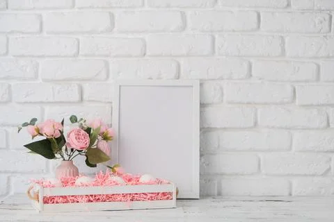 Easter background with eggs in basket, spring flowers and white frame for m.. 스톡 사진