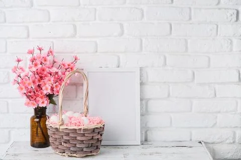 Easter background with eggs in basket, spring flower and white frame for mock 스톡 사진