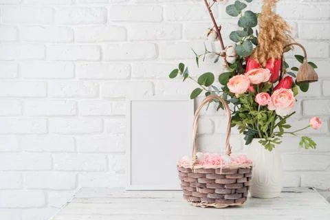Easter background with eggs in basket, spring flower and white frame for mock Stockfoto's