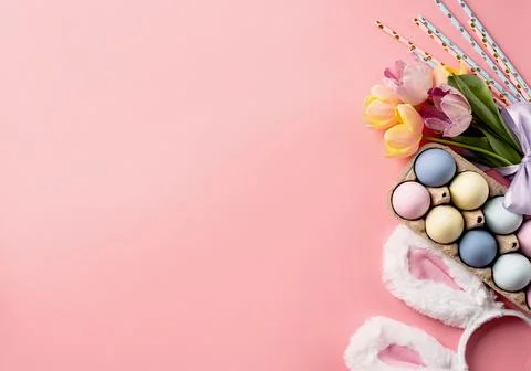 Easter background with eggs, bunny ears and tulips on pink backdrop, top vi.. Stockfoto's