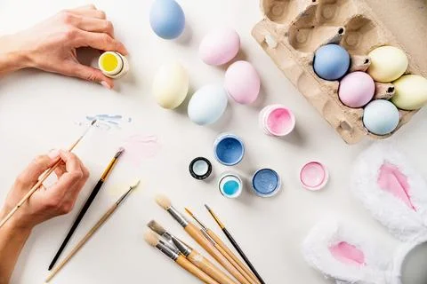 Easter background with eggs with pastel paints, top view flat lay Stock Photos