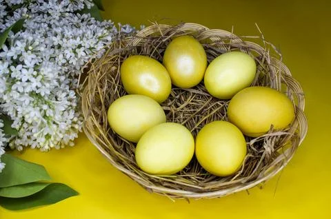 Easter background with gold eggs and white lilac flowers Foto stock
