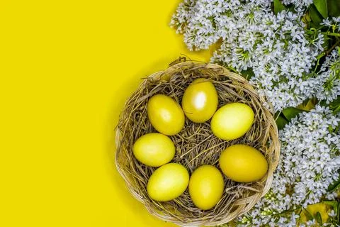 Easter background with gold eggs and white lilac flowers Stock Photos