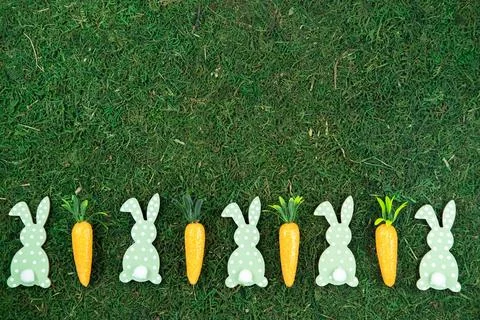 Easter background made of decorative carrots and bunny rabbits on natural Stock-Fotos