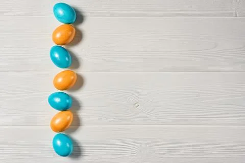 Easter background with painted eggs on a white wooden background with copy sp Stock Photos