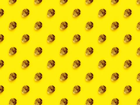 The easter background with the quail brown eggs pattern on the trendy yellow. Stock Photos