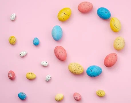 Easter background, shape with a multi-colored eggs lie on a pink table. - C.. Stock Photos