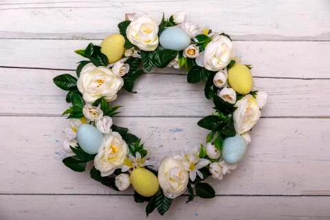 Easter background with spring easter eggs and flowers, wreath on door Stock Photos