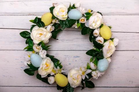 Easter background with spring easter eggs and flowers, wreath on door Stock Photos