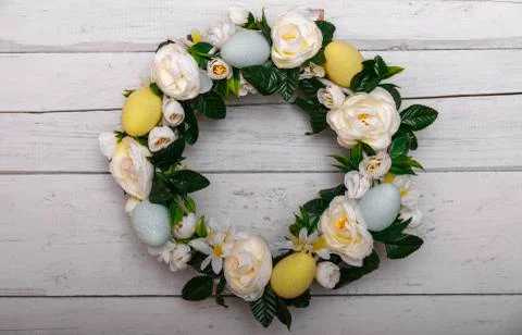 Easter background with spring easter eggs and flowers, wreath on door Stock Photos