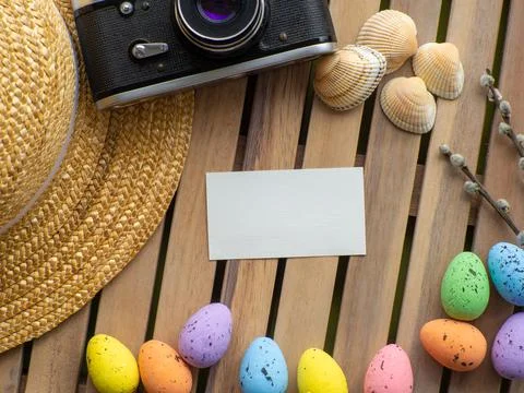 Easter background with straw hat, photo camera, colorful eggs and white rabbit Stock Photos