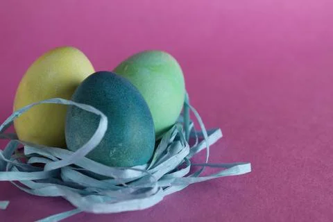 Easter background three multicolored eggs are candy next to a pink background Foto stock