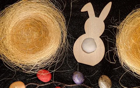 Easter background top view with rabbit, painted eggs, nests on dark background Stock Photos