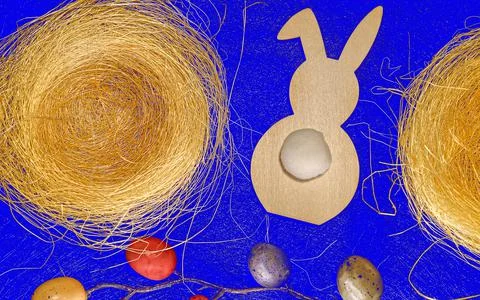 Easter background top view with rabbit, painted eggs, nests on bright blue Stock Photos
