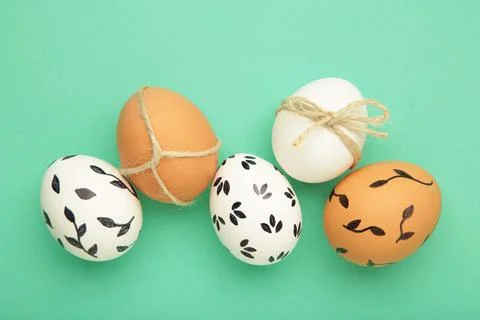 Easter background - white easter egg with flowers inside on mint background.  Stock Photos