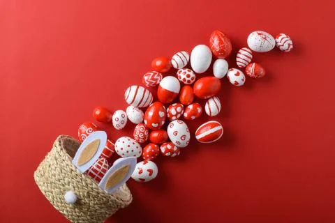 Easter backgrounds with a basket in the shape of a hare and red and white eggs Stock Photos