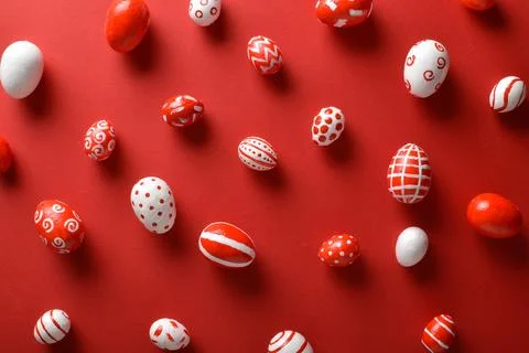 Easter backgrounds, scattered Easter red and white eggs on a bright red backg Foto stock