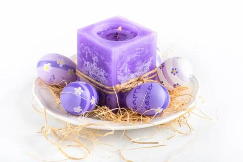 Easter background.Violet candle and easter eggs on a white background 스톡 사진