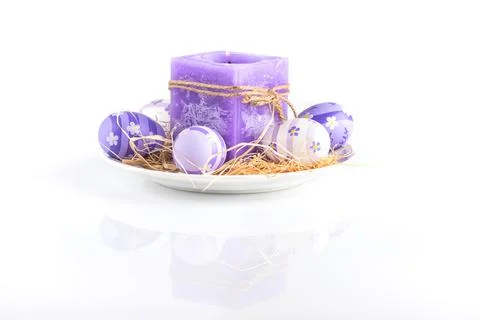 Easter background.Violet candle and easter eggs on a white background 스톡 사진