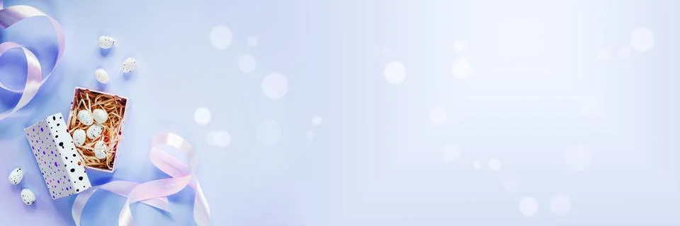 Easter banner with Easter eggs in a gift box with pink ribbons on purple Stock Photos