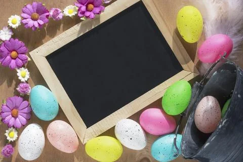 Easter banner with a rustic bucket full of painted eggs overturned on a table Stockfoto's